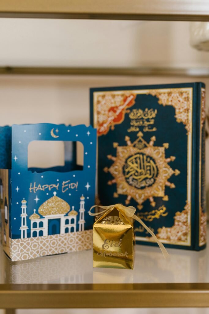 Golden gift box and Quran with decorative Eid-themed packaging for celebration.